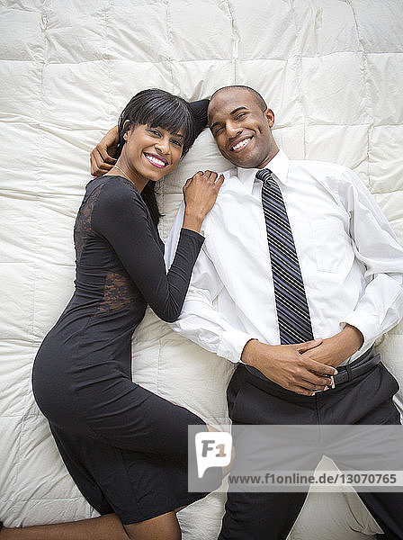 Portrait of smiling couple lying on bed