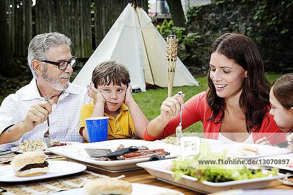 Family having food at table in lawn