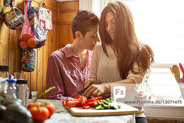 Zärtliches lesbisches Paar  das zu Hause in der Küche sitzt