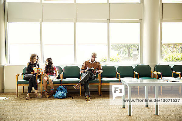 Patienten  die auf Stühlen im Wartezimmer sitzen
