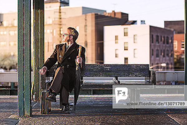 Geschäftsmann schaut weg  während er auf einer Bank in der U-Bahn-Station sitzt