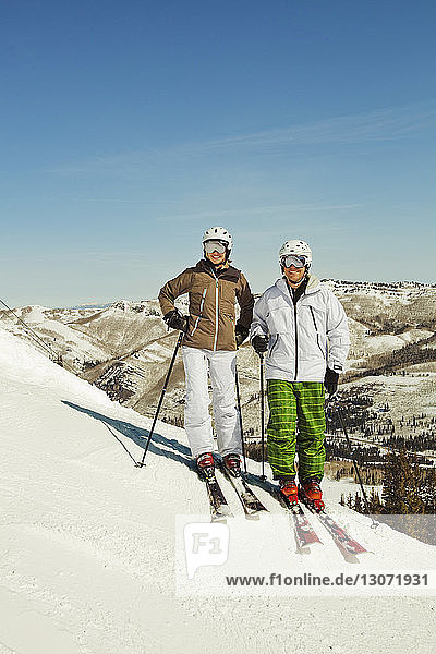 Porträt von Skifahrern auf schneebedecktem Feld stehend