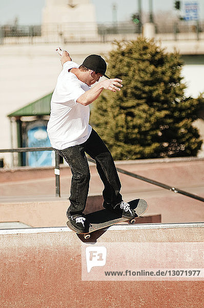 Seitenansicht eines Mannes beim Skateboarden im Park an einem sonnigen Tag