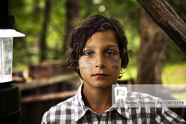 Bildnis eines auf dem Feld stehenden Jungen mit Gesichtsbemalung
