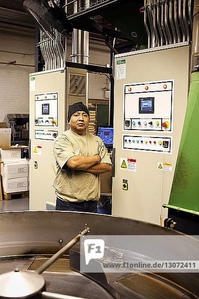 Porträt eines selbstbewussten Arbeiters am Kaffeeröster in der Industrie