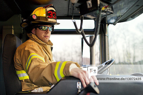 Firefighter with sunglasses sitting in fire engine