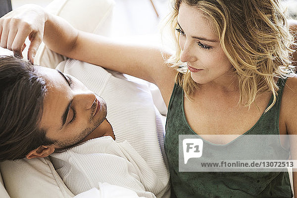 High angle view of romantic couple relaxing on sofa