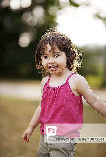 Portrait of cute girl standing on field