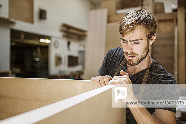 Mann arbeitet auf einem Holzbrett in einer Schreinerei