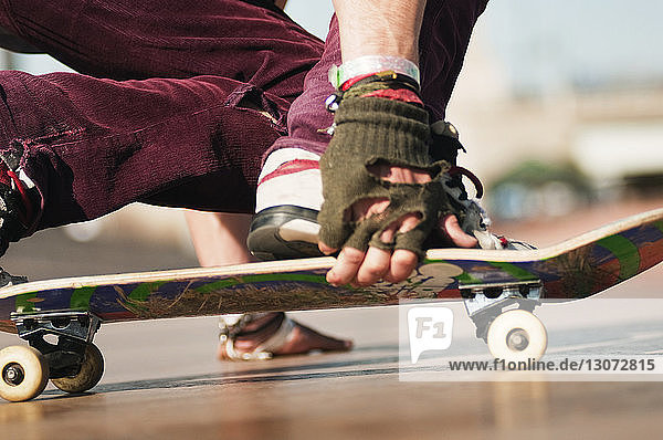 Oberflächenniveau eines jungen Mannes beim Skateboarden auf einem Fußweg