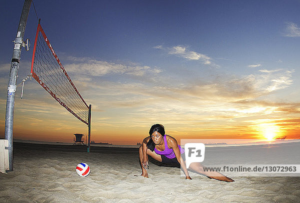 Frau schaut weg  während sie am Strand Sport treibt
