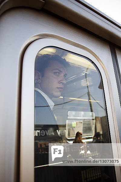 Geschäftsmann schaut durch Zugfenster weg
