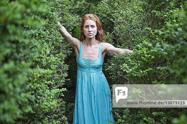 Porträt einer ernsten Frau im Wald stehend