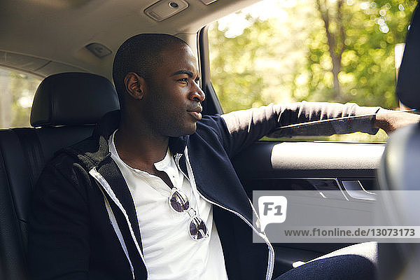 Man looking away while traveling in car