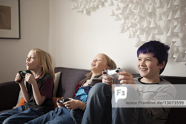 Boys sitting on sofa and playing video game