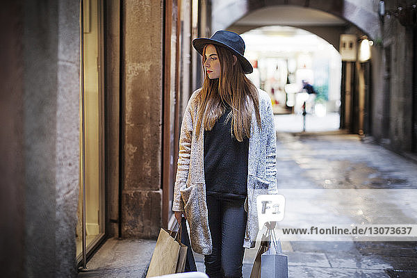 Frau trägt Einkaufstaschen beim Gehen auf dem Fussweg