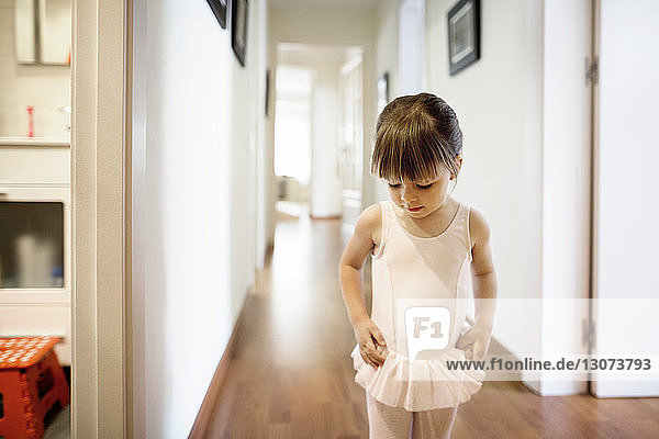 Süßes Mädchen im Ballerina-Kostüm zu Hause stehend