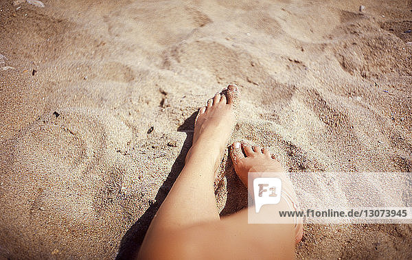 Niedriger Abschnitt einer Frau  die sich im Sommer am Strand auf Sand ausruht