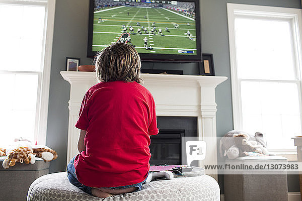 Low angle view of boy playing video game on television set at home
