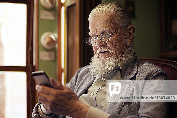 Senior man texting in living room