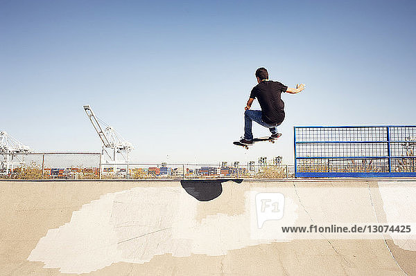 Low angle view of man performing stunt in skateboard park