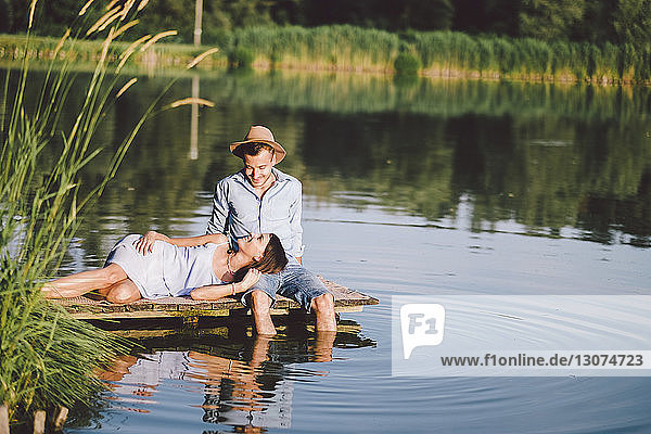 girlfriend lying on boyfriend's lap by lake at park