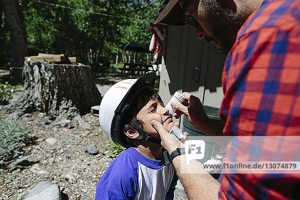 Father applying medicine on son's nose at Inyo National Forest