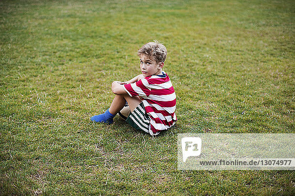 Porträt eines auf Gras sitzenden Jungen