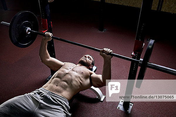 High angle view of man lifting barbells in gym