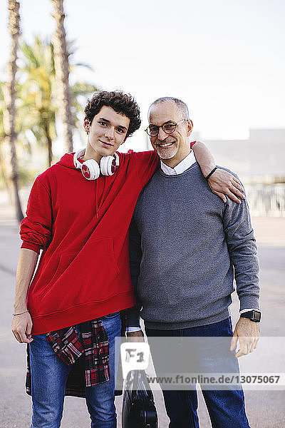 Portrait of confident son and father in city