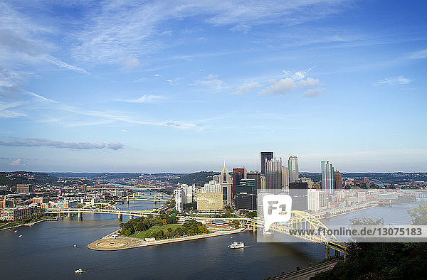 High angle view of bridges over river in Pittsburgh city against blue sky