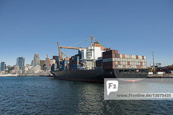 Containerschiff vertäut im Handelsdock vor blauem Himmel