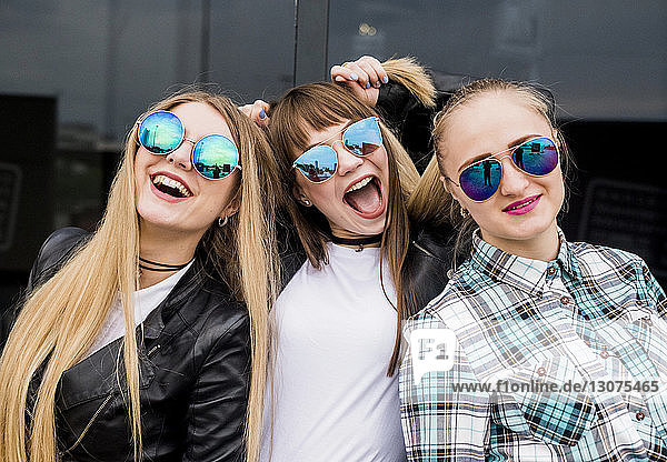 Porträt von glücklichen Freundinnen mit Sonnenbrille in der Stadt