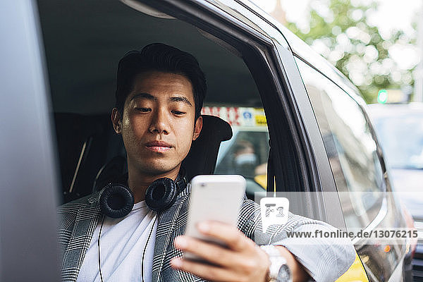 Geschäftsmann mit Smartphone im Taxi