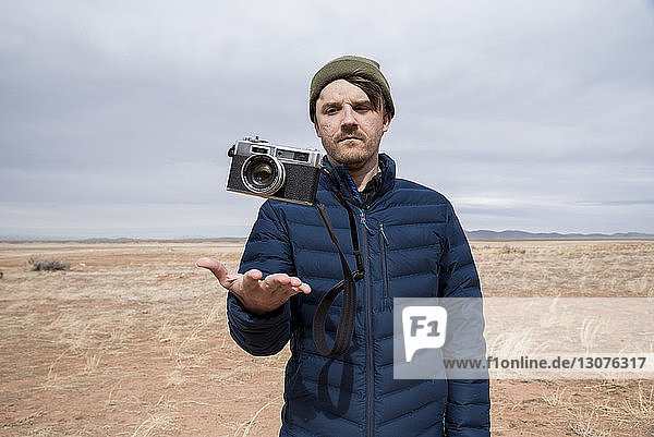 Man looking at camera in air at desert against sky