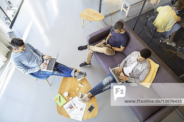 High angle view of male colleagues working in room at office