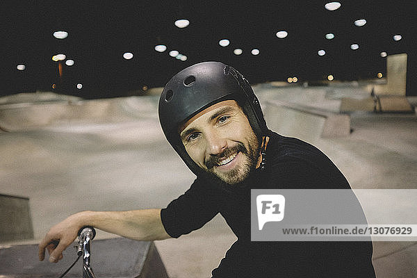 Porträt eines lächelnden Mannes mit Fahrrad im Skateboard-Park