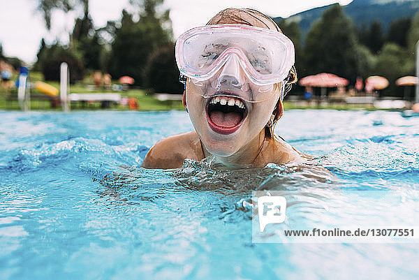 Nahaufnahme eines glücklichen Mädchens mit offenem Mund beim Schwimmen im Schwimmbad