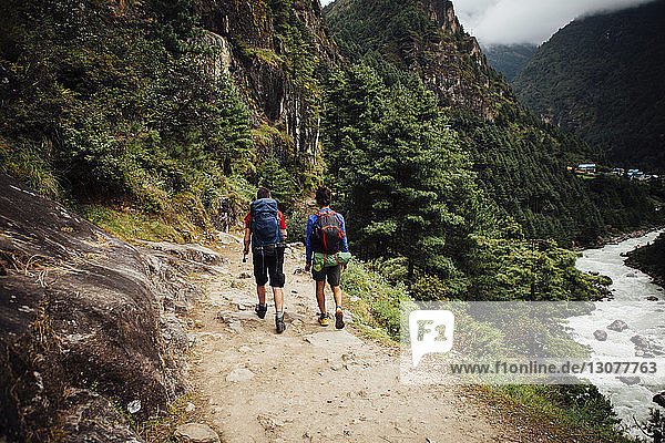 Rear view of friends with backpacks hiking at Sagarmatha National Park