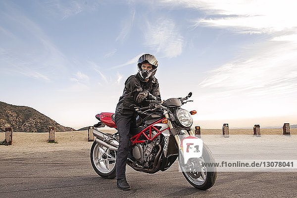 Porträt eines auf einem Motorrad sitzenden Bikers mit Helm