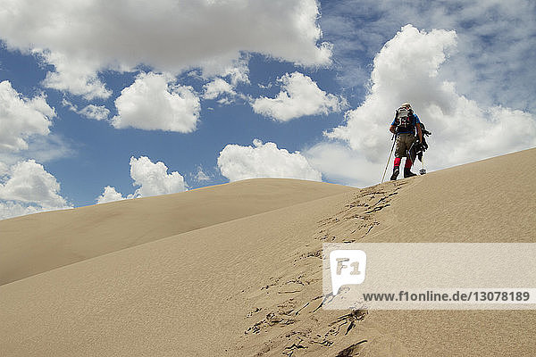 Low angle view of hiker walking in desert