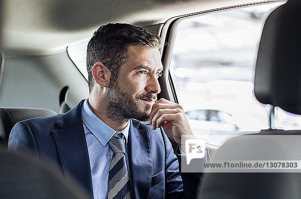 Nachdenklicher Geschäftsmann sitzt im Auto