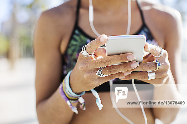 Ein Teil der sportlichen Frau benutzt im Sommer ein Smartphone