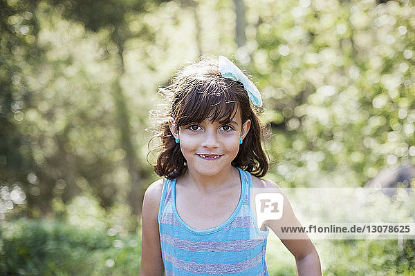 Porträt eines niedlichen Mädchens  das im Wald lächelt