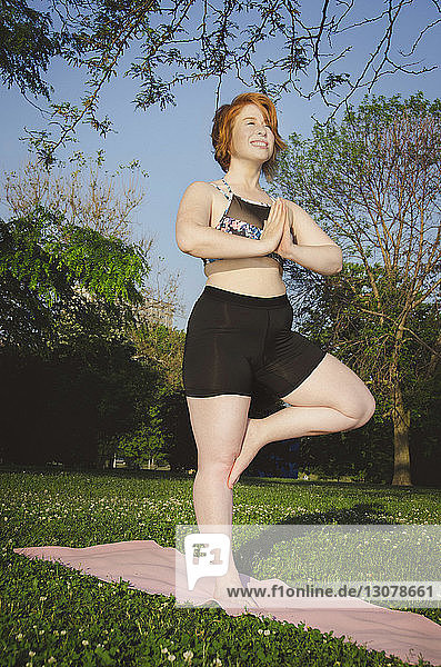 Tiefwinkelansicht einer Frau  die im Park Baumpose-Yoga praktiziert