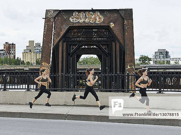 Sportliche Frau joggt beim Training auf der Brücke in der Stadt