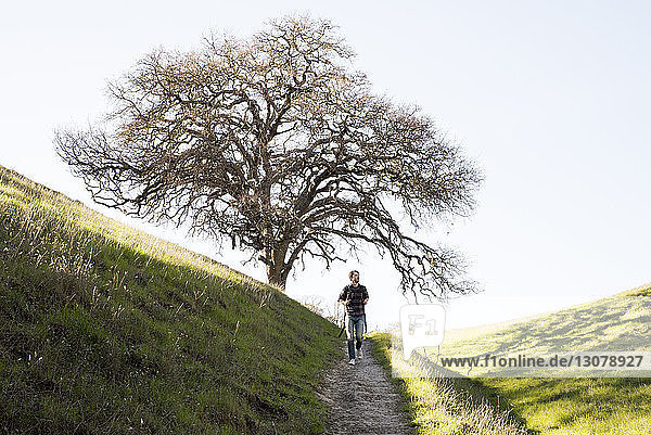 Male hiker hiking on mountain against sky