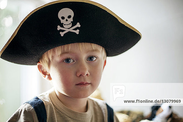 Portrait of boy in pirate hat sitting at home