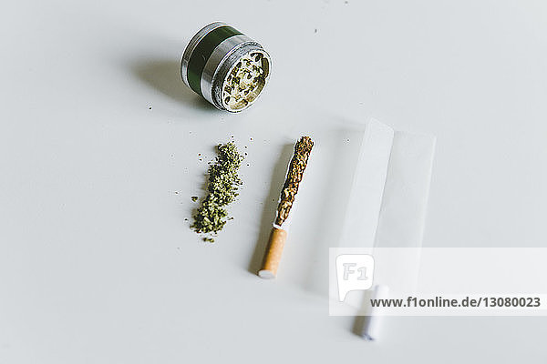 Draufsicht auf Marihuana-Joints  Zigarette mit Papier und Schleifer auf weißem Tisch
