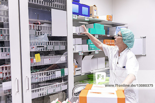 Ärztin sucht Medikamentenkisten im Lagerraum des Krankenhauses